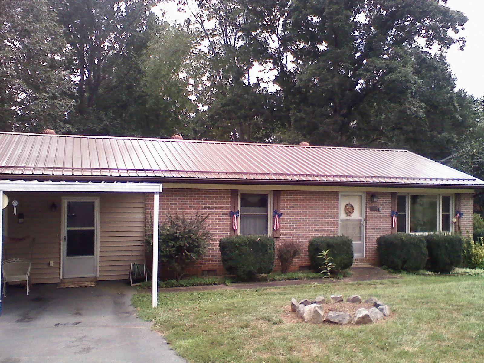 Bronze metal roof and carport on a brick ranch home — Roof Repair work by our crew in Hesston