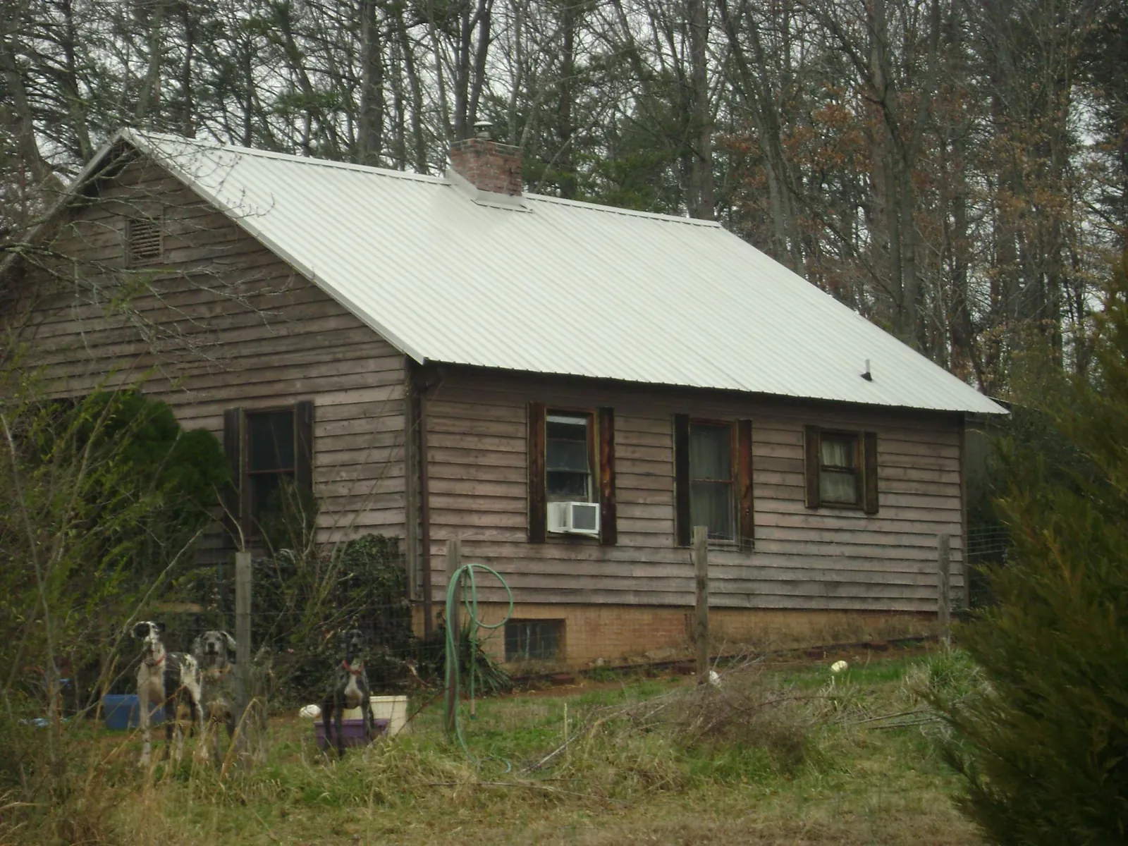White metal roof on an old wood sided farmhouse, from a Metal Roof Installation job in Hesston